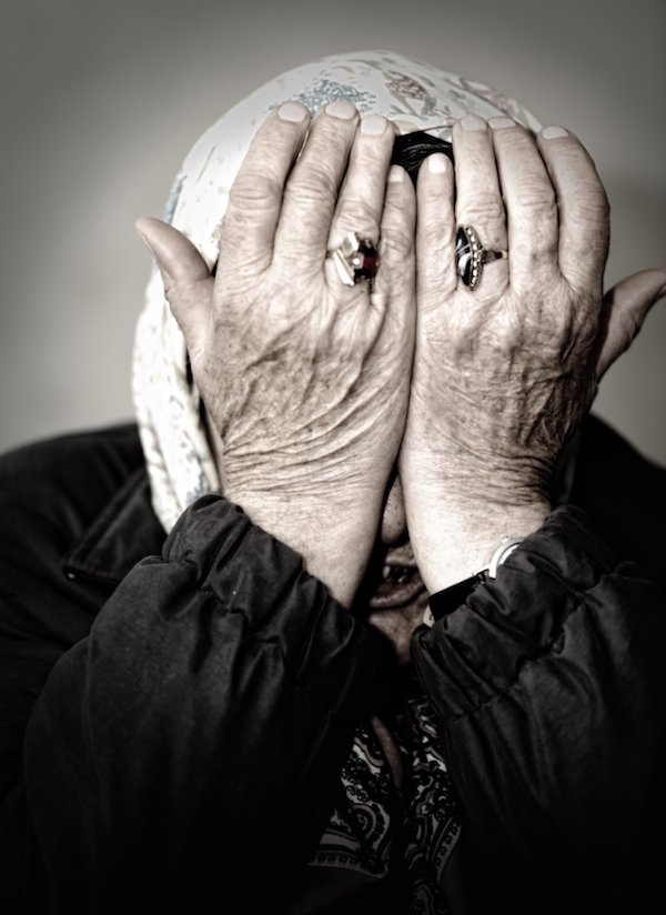 Mature woman crying with hands on her face
